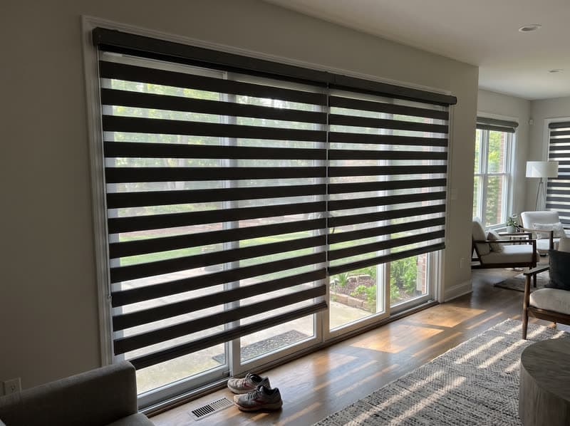 Wide charcoal zebra shade over a sliding glass door in a Johns Creek family room