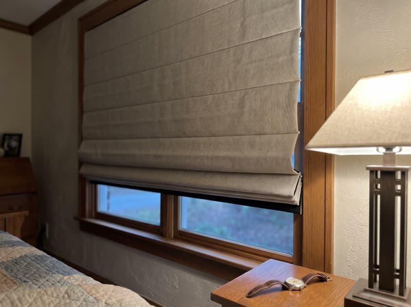 Greige lined roman shade lowered in an Atlanta bedroom