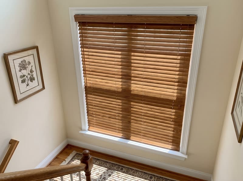 Wood blind on a stairwell landing window in a traditional two-storey house in Buford