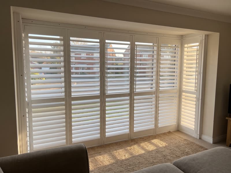Composite shutters on a living room window in a 1990s brick colonial in Alpharetta
