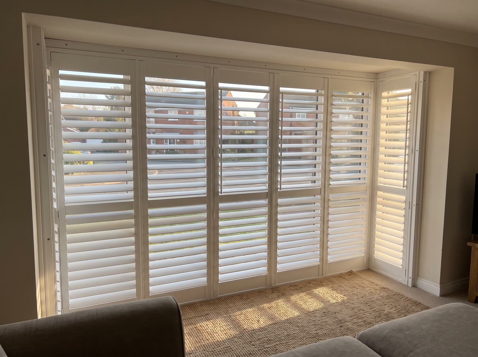 Composite shutters on a living room window in a 1990s brick colonial in Alpharetta