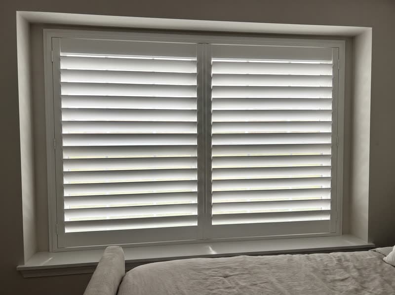 Composite shutters on a primary bedroom window in a modern farmhouse in Milton