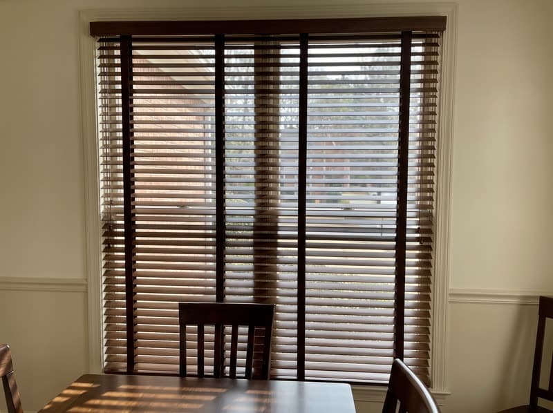 Dark walnut real wood blinds on a tall dining room window in a Roswell colonial